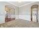 A vacant living room featuring a mix of carpeted and wood flooring with decorative molding at 13494 Moorcroft Dr, Fishers, IN 46037