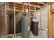 Utility room with a water heater, water softener, and wood-framed walls at 13494 Moorcroft Dr, Fishers, IN 46037