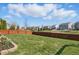 Backyard with lush green lawn and well-maintained landscaping, enclosed by a fence and overlooking a serene pond at 1575 Oakvista Dr, Greenwood, IN 46143