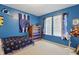 Bright blue bedroom features natural light, sports decor, and carpet at 1575 Oakvista Dr, Greenwood, IN 46143