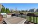 Deck boasts scenic backyard and pond views, framed by lush greenery; features an outdoor dining table for six at 1575 Oakvista Dr, Greenwood, IN 46143