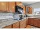 Close-up of a kitchen counter, with wood cabinets, granite countertops, and modern appliances at 1575 Oakvista Dr, Greenwood, IN 46143