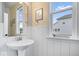 Charming bathroom with wainscoting, a pedestal sink, and a window with a view at 16193 Burnt Rock Ln, Fortville, IN 46040