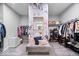 Spacious walk-in closet with floral wallpaper, a bench, and ample storage for clothes and shoes at 16193 Burnt Rock Ln, Fortville, IN 46040