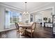 Elegant dining room with hardwood floors, modern chandelier, and lots of natural light from the large window at 16193 Burnt Rock Ln, Fortville, IN 46040