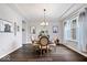 Dining room features hardwood floors, a modern chandelier, and ample natural light from the large window at 16193 Burnt Rock Ln, Fortville, IN 46040