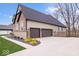 Side view of a tan house featuring a two-car garage with a concrete driveway and professional landscaping at 16193 Burnt Rock Ln, Fortville, IN 46040