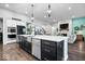 A kitchen with an island featuring stainless appliances, a sink, and seating area with an open-concept living space at 16193 Burnt Rock Ln, Fortville, IN 46040