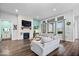 A spacious living room with hardwood floors, a fireplace, and large windows at 16193 Burnt Rock Ln, Fortville, IN 46040