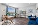 Bright living room showcasing stylish decor, large window, hardwood floors, blue velvet chairs, and modern furniture at 16193 Burnt Rock Ln, Fortville, IN 46040