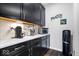 A well-appointed pantry area with dark cabinets, quartz countertops, and modern coffee appliances at 16193 Burnt Rock Ln, Fortville, IN 46040