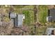 Aerial view of a home with a gray roof, a fenced yard, a patio with furniture, and mature trees at 1707 W 76Th Pl, Indianapolis, IN 46260