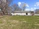 Spacious backyard with large grass area and mature trees, perfect for outdoor activities at 1707 W 76Th Pl, Indianapolis, IN 46260