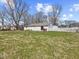 Large backyard features a patio, fence, and mature trees, perfect for outdoor enjoyment and privacy at 1707 W 76Th Pl, Indianapolis, IN 46260