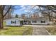 Charming single-story home featuring light blue siding, dark shutters, a fountain, and a paved driveway at 1707 W 76Th Pl, Indianapolis, IN 46260