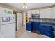 Kitchen with white cabinets and view of the sliding door and appliances at 1707 W 76Th Pl, Indianapolis, IN 46260