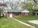 Charming brick home with green shutters, a well-manicured lawn, and a welcoming walkway at 2120 Sheffield Ave, Anderson, IN 46011