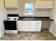 Well-lit kitchen featuring white cabinets, laminate countertops and essential appliances at 2120 Sheffield Ave, Anderson, IN 46011