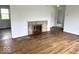 Bright living room featuring a decorative fireplace and gleaming hardwood floors at 2120 Sheffield Ave, Anderson, IN 46011