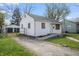 Quaint single-story home with a gravel driveway, detached garage, and a small front porch at 2221 Groff Ave, Indianapolis, IN 46222