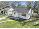 Charming home featuring white siding, a grey roof, and a well-manicured lawn with a brick-lined walkway at 2221 Groff Ave, Indianapolis, IN 46222