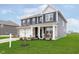 Attractive blue two-story home with a covered porch, stone accents, and a lush green lawn at 2538 Redding Dr, Whitestown, IN 46075