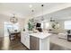 Open-concept kitchen flowing into dining and living areas, featuring a large island and stainless steel appliances at 2538 Redding Dr, Whitestown, IN 46075