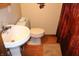 A bathroom with a pedestal sink, toilet, and brown patterned shower curtain at 2692 E County Road 750 S, Clayton, IN 46118