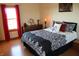 A modern bedroom with a large bed, a dark floral pattern comforter, and red accents at 2692 E County Road 750 S, Clayton, IN 46118