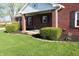 Close-up of a brick home with manicured bushes and a covered porch, creating a welcoming entrance at 2692 E County Road 750 S, Clayton, IN 46118