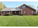 Charming red brick home featuring a gable roof, manicured lawn, and lovely landscaping at 2692 E County Road 750 S, Clayton, IN 46118