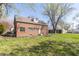 Brick home featuring a well-maintained backyard with mature trees providing shade and an American flag at 2741 Mars Hill St, Indianapolis, IN 46241