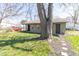 View of the detached garage showcasing a green lawn and a mature tree offering shade in spring at 2741 Mars Hill St, Indianapolis, IN 46241