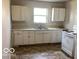Functional kitchen featuring white cabinets, a standard sink, and a basic electric range at 2823 N Gladstone Ave, Indianapolis, IN 46218