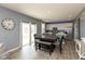 Open kitchen and dining area featuring gray walls, wood floors, a large dining table, and white kitchen cabinets at 2960 W Patchwork Dr, Monrovia, IN 46157