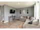 Comfortable living room featuring gray walls, wood floors, a gray sectional sofa, and a mounted TV at 2960 W Patchwork Dr, Monrovia, IN 46157