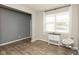 Bright and airy room with light gray and blue walls, wood floors, and a large window with white curtains at 2960 W Patchwork Dr, Monrovia, IN 46157