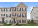 Charming brick townhome featuring black shutters, a peaked roof, and manicured front lawn at 3527 Brampton Ln, Westfield, IN 46074