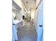 Long bathroom with gray tiled floor, cabinets, large mirror, and glass shower at 359 N Jefferson St, Martinsville, IN 46151