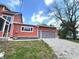 Home's exterior featuring red siding and a gray two-car garage with a stone driveway at 359 N Jefferson St, Martinsville, IN 46151