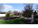 A backyard with lush green lawn, flowers, brick features, and natural landscaping offers a serene outdoor retreat at 3790 E Pleasant Run Parkway North Dr, Indianapolis, IN 46201