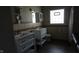 Bathroom with a double sink vanity, tiled walls, dark tile floors, bright lighting and a large, decorative mirror at 3790 E Pleasant Run Parkway North Dr, Indianapolis, IN 46201