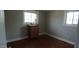 This bedroom features two windows that provide natural light, highlighting the hardwood floors and traditional furniture at 3790 E Pleasant Run Parkway North Dr, Indianapolis, IN 46201