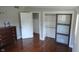 Bedroom featuring wood flooring, neutral walls, an open closet with shelving, and built in dresser at 3790 E Pleasant Run Parkway North Dr, Indianapolis, IN 46201