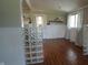 Open-concept dining room with wood flooring, white wainscoting, large windows, and modern lighting fixtures at 3790 E Pleasant Run Parkway North Dr, Indianapolis, IN 46201