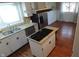 Bright kitchen featuring granite countertops, a central island with cooktop, stainless steel appliances, and wood flooring at 3790 E Pleasant Run Parkway North Dr, Indianapolis, IN 46201
