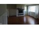 Cozy living room with wood flooring, a fireplace with tile surround, wainscoting, and large windows at 3790 E Pleasant Run Parkway North Dr, Indianapolis, IN 46201