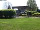 Beautifully landscaped front yard with a wooden pergola and lush green lawn, creating a welcoming entrance at 4309 Summerhaven Dr, New Palestine, IN 46163