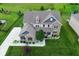 Aerial shot of a beautiful house boasting manicured lawns, mature trees, and a basketball hoop at 4415 Voyageur Way, Carmel, IN 46074