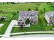 Aerial view of a beautiful home featuring a well-manicured lawn, lush landscaping, and a spacious driveway at 4415 Voyageur Way, Carmel, IN 46074